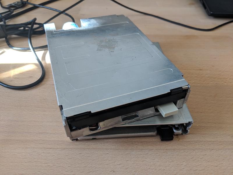 Two 3.5-inch floppy drives stacked on top of each other, disconnected.