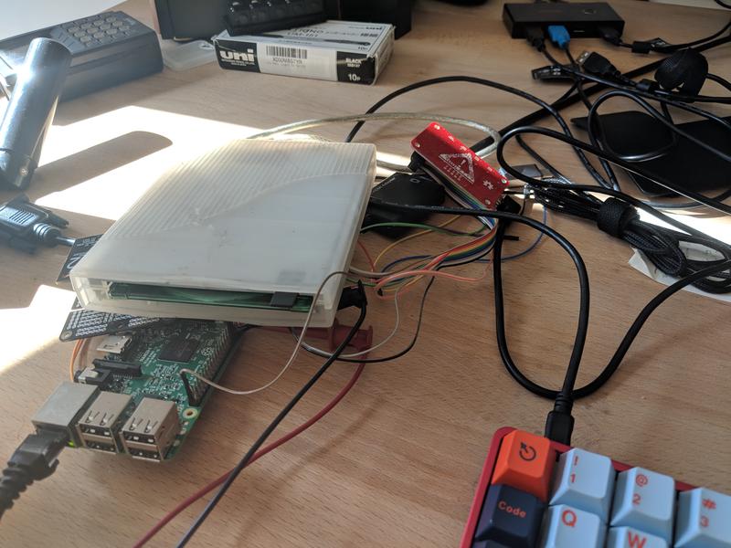 Raspberry Pi hidden beneath floppy drive and mess of wires.